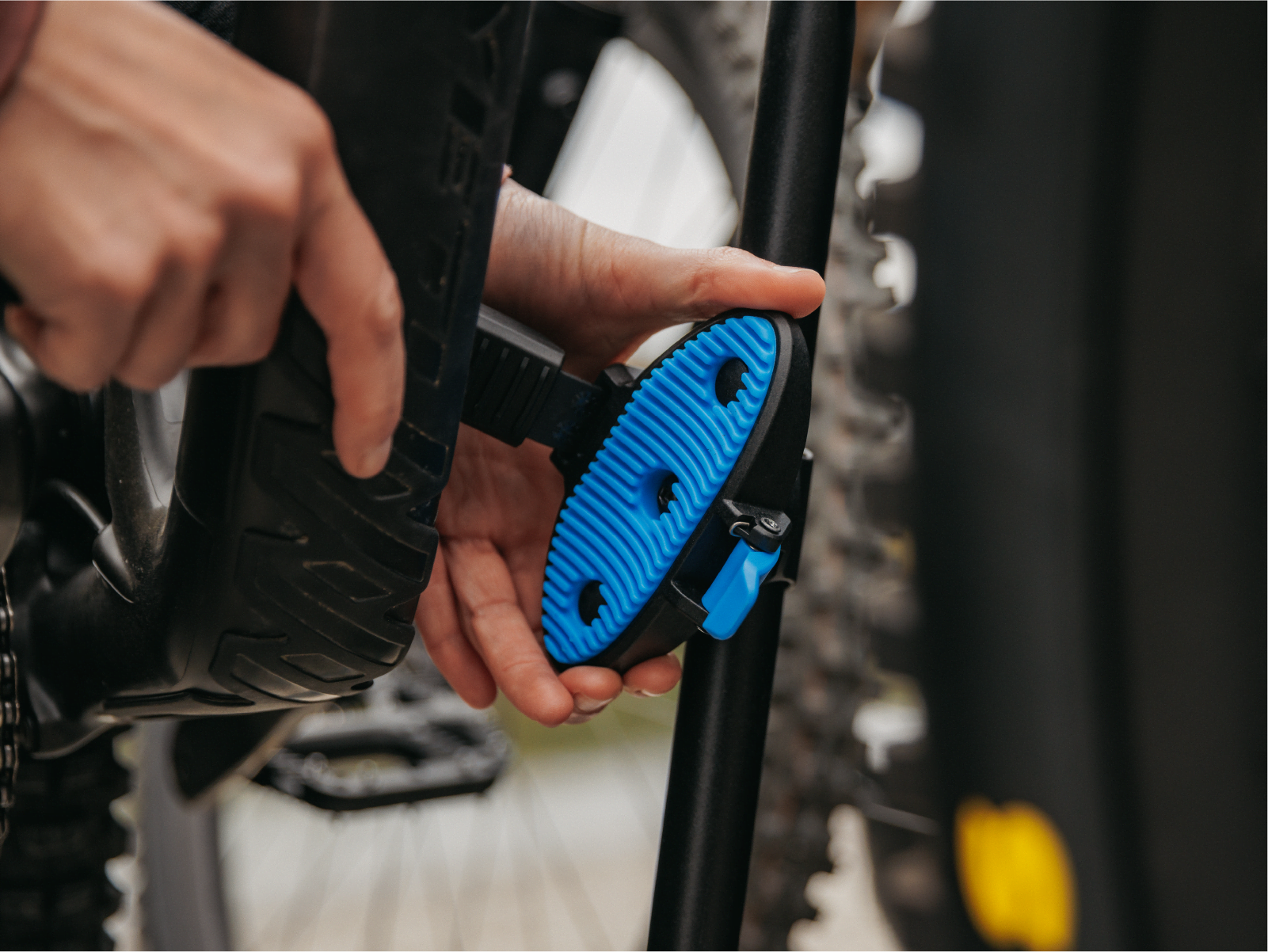 A man is rotating the cradle of a frame clamp on the Enduro bike racks