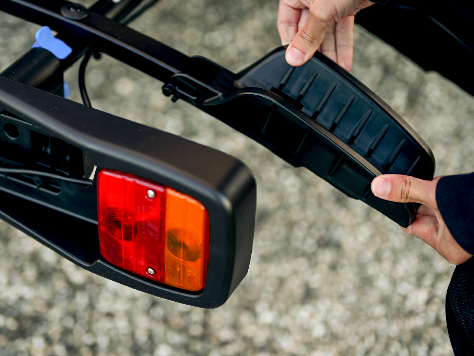 A man adjusts the position of the wheel tray of an enduro 4 bike rack