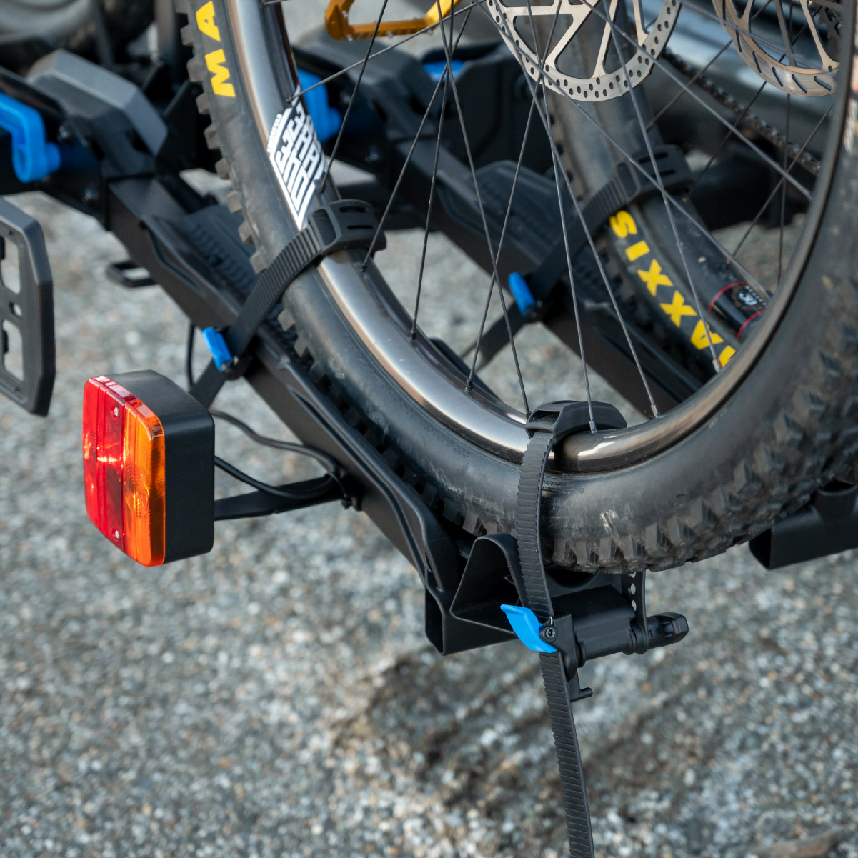 A close up view of the front tire of an ebike restrained in the Ezigrip E-Rack 2 Pro ebike rack with the anti-sway ratchet strap holding the front tire