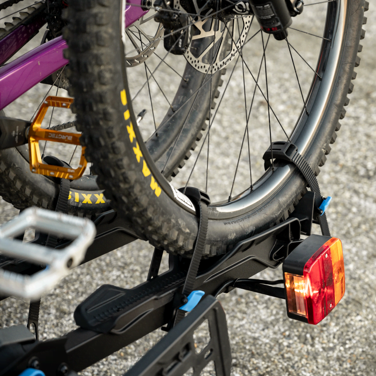 A close view of the wheel tray of the Ezigrip E-Rack 2 Pro ebike rack with the ratchet strap and anti-sway ratchet strap restraining the front tire of an electric bike