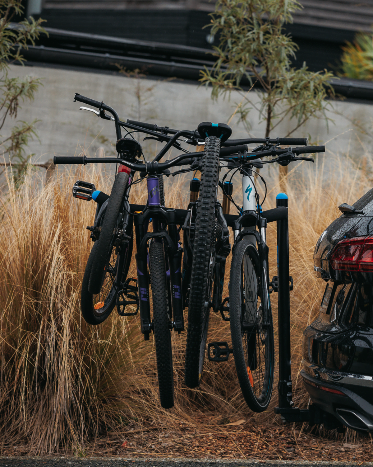 A side view of an Advantage 4 prong bike rack mounted to an SUV with 4 bikes strapped to the prongs of the bike rack