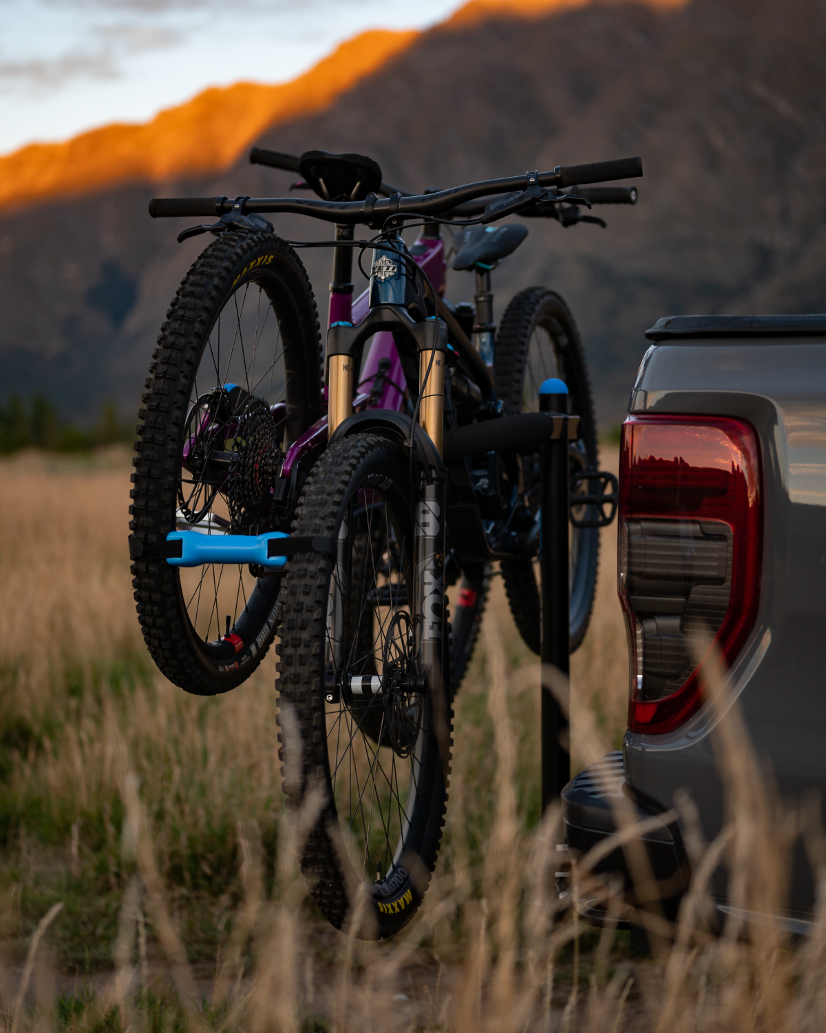 A side view of two bikes strapped to an advantage 2 prong rack mounted to the back of a ute. A bike bone is keeping the bikes separated.
