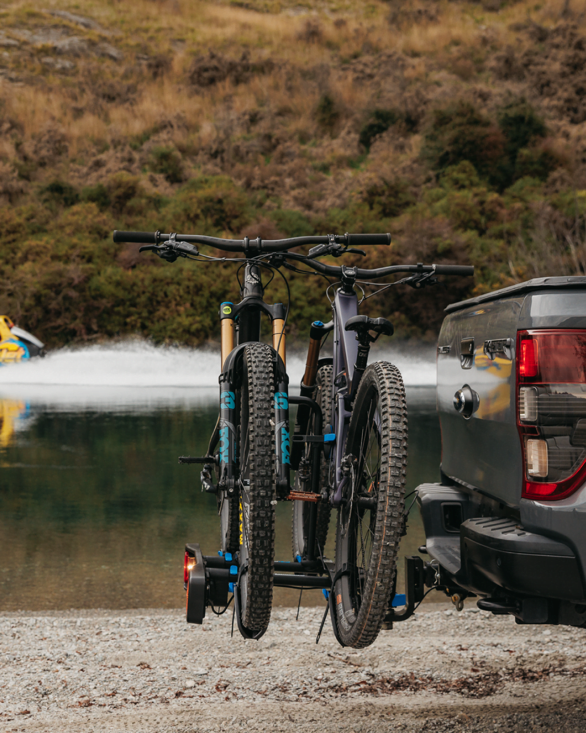 A side view of an Enduro 2 bike rack with 2 mountain bikes loaded on the bike rack on the back of a ute with generous spacing between mountain bikes