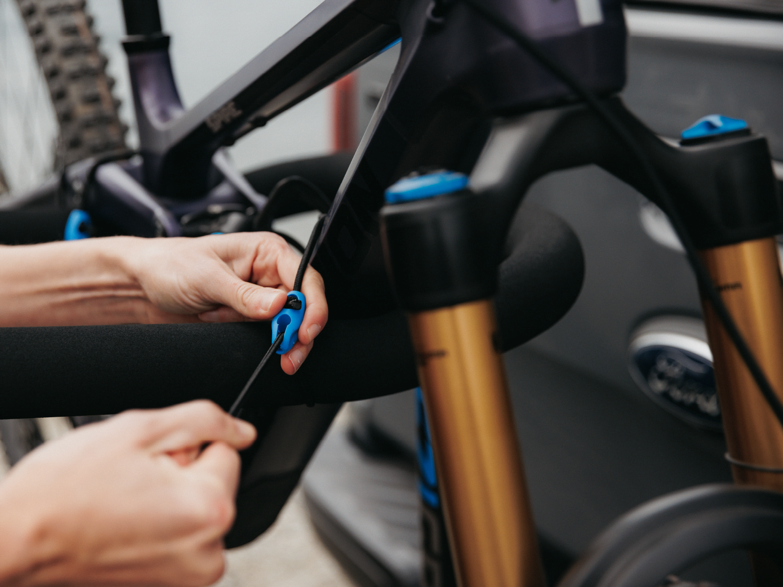 A woman is doing up a bungee chord on the Advantage 4 bike rack to restrain her mtb