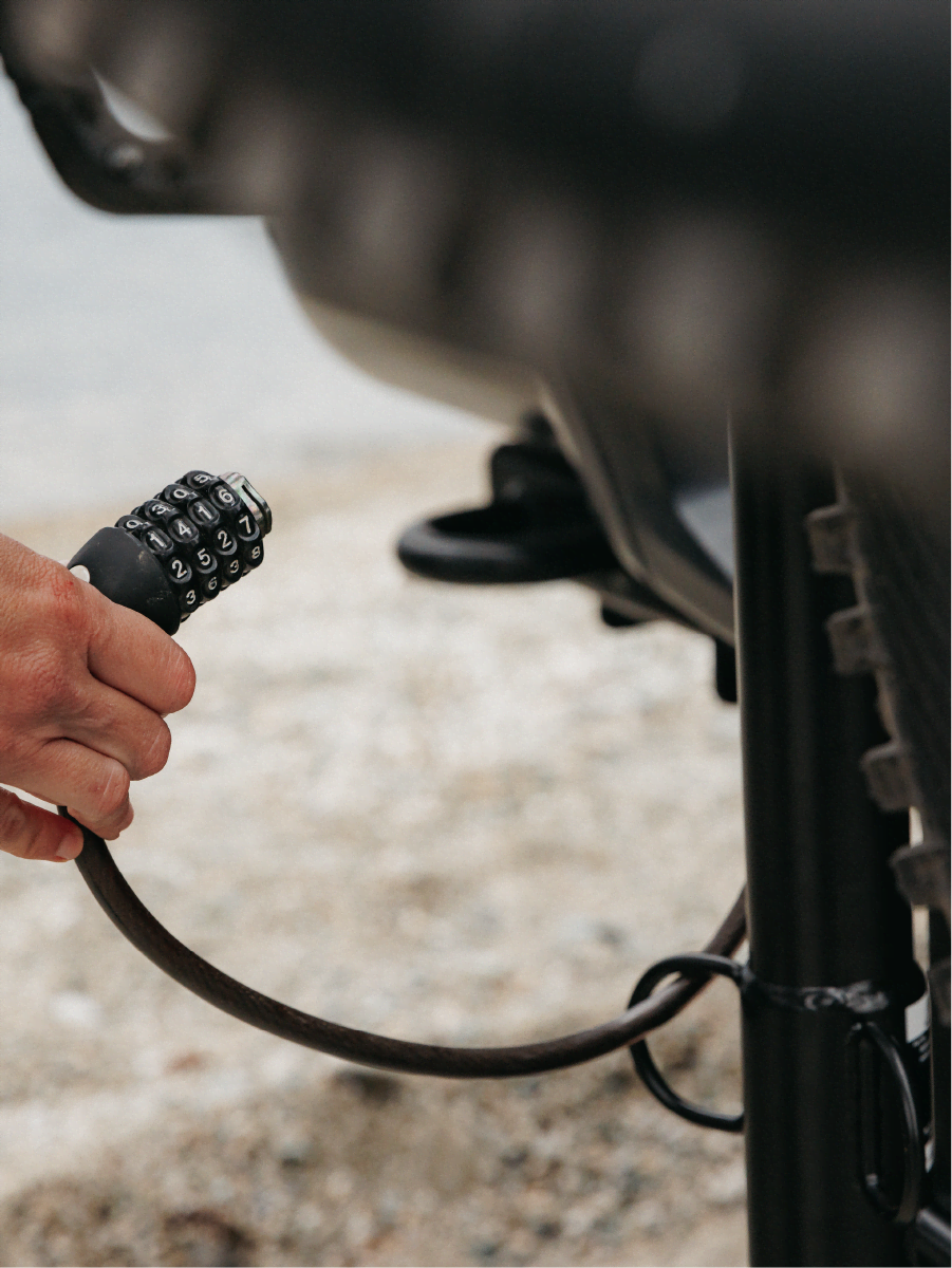 A woman is using a bike lock to lock the bikes to the bike rack
