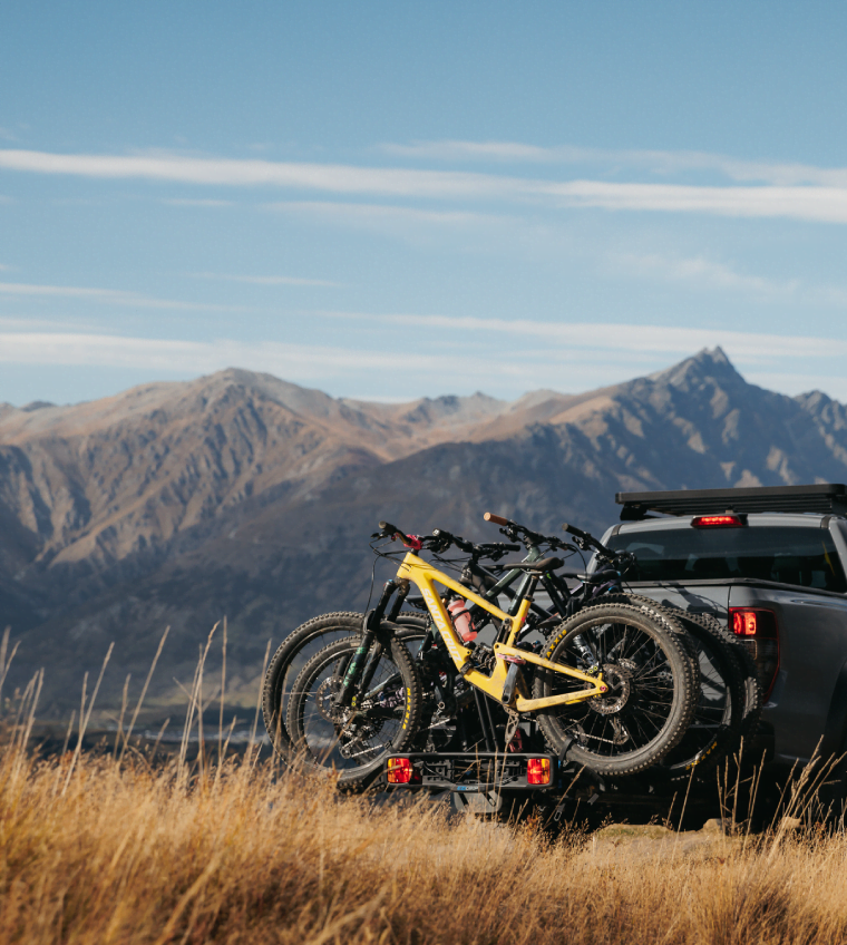 An Ezigrip Enduro 4 bike rack loaded with 4 mtbs is visible on a vehicle in front of the new zealand southern alps