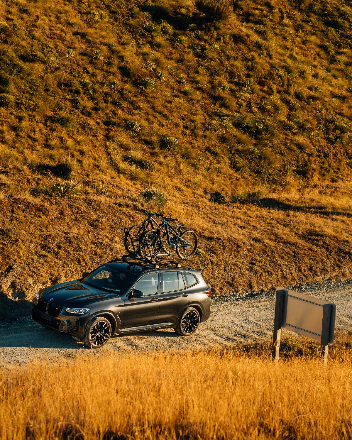two mountain bikes are strapped into ezigrip uplift 1s atop a black suv