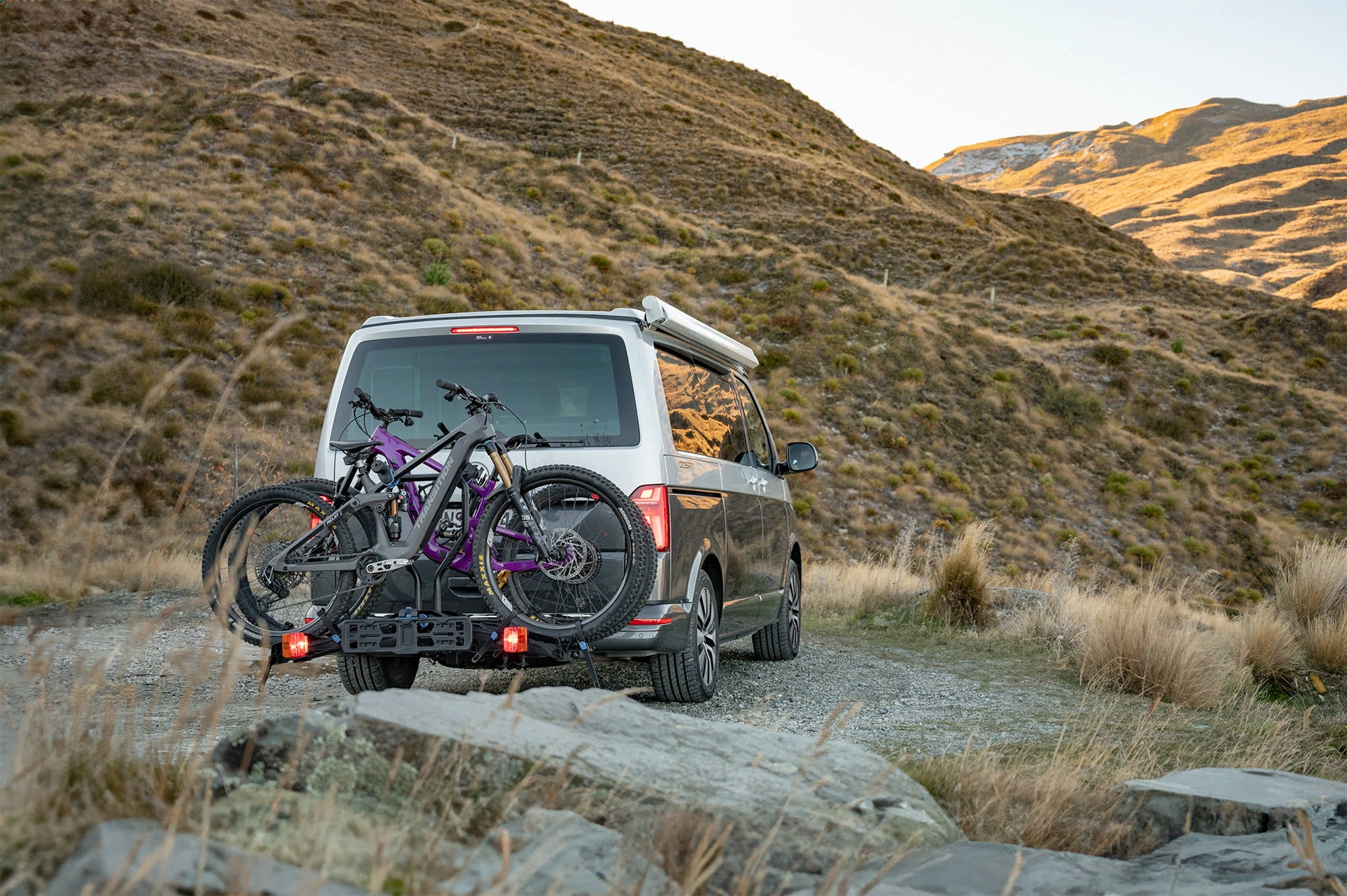 An Ezigrip E-Rack 2 is mounted to a van, carrying two electric bikes at the foot of the mountains in New Zealand