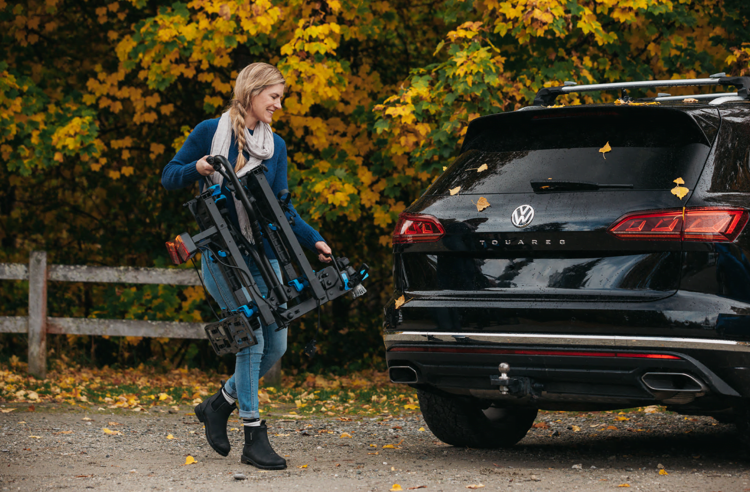 A woman carries an Ezigrip E-Rack 2 e bike rack to a vehicle