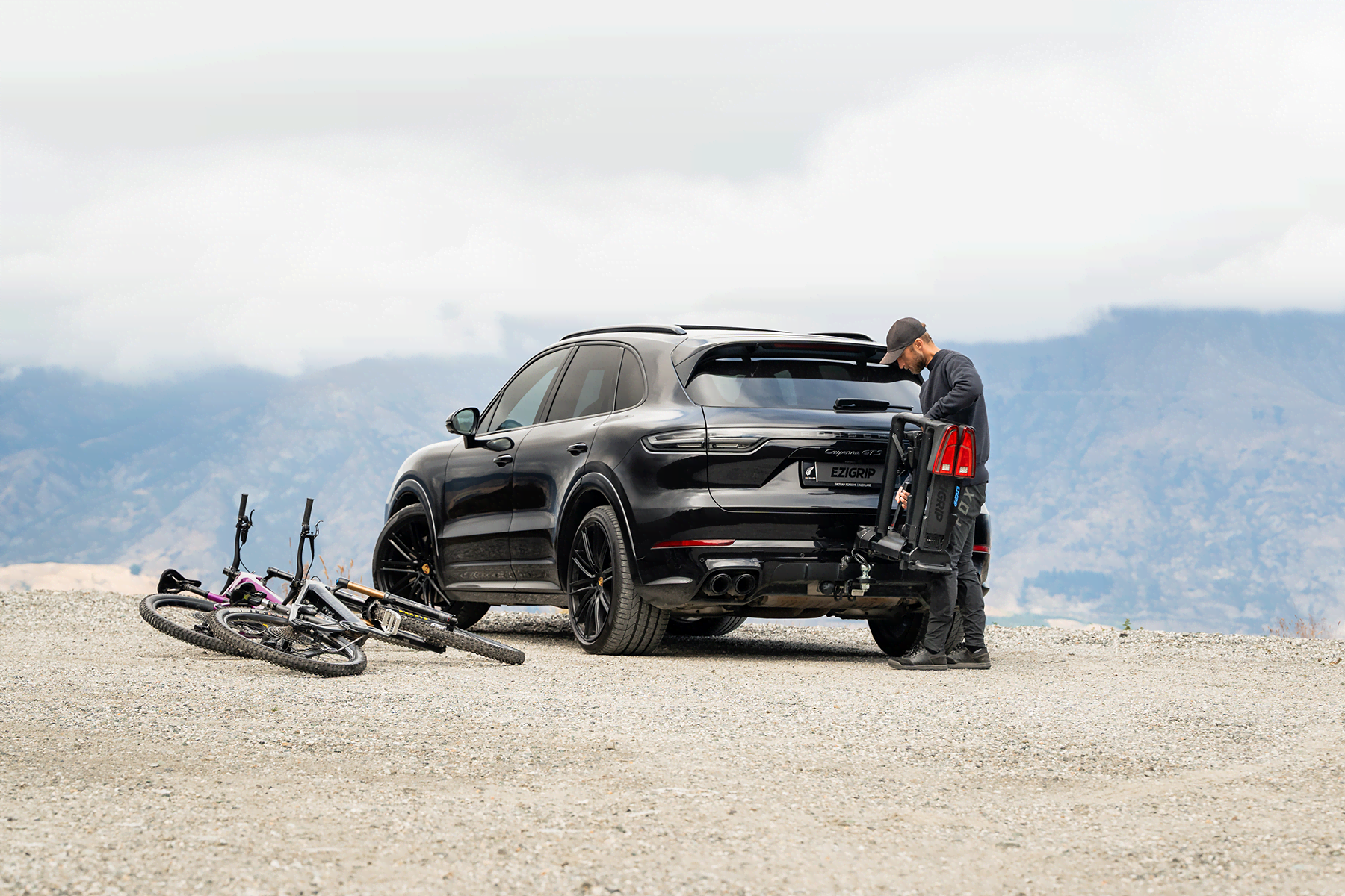 A man installs the Ezigrip E-Volve 2 onto the tow ball of a Porsche SUV