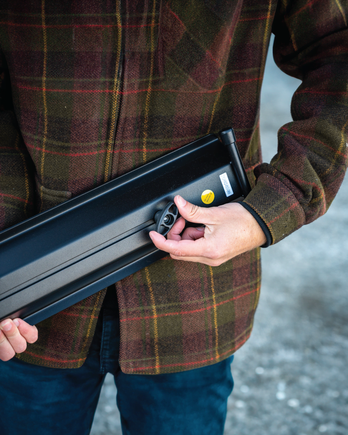 A man is adjusting the wing nut of the telescoping connection on the E-Rack 2 Pro ramp accessory