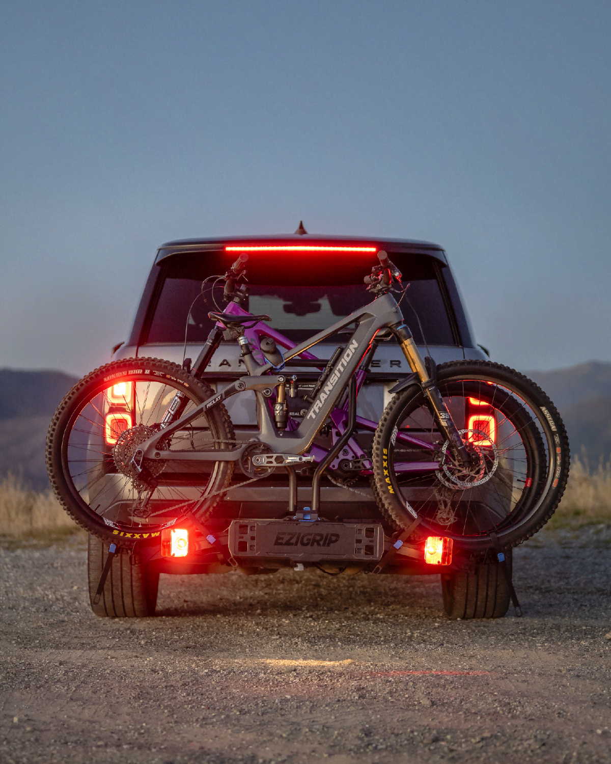 Two emtbs sit snug in an Ezigrip E-Rack 2 Pro bike rack on the back of a Range Rover SUV