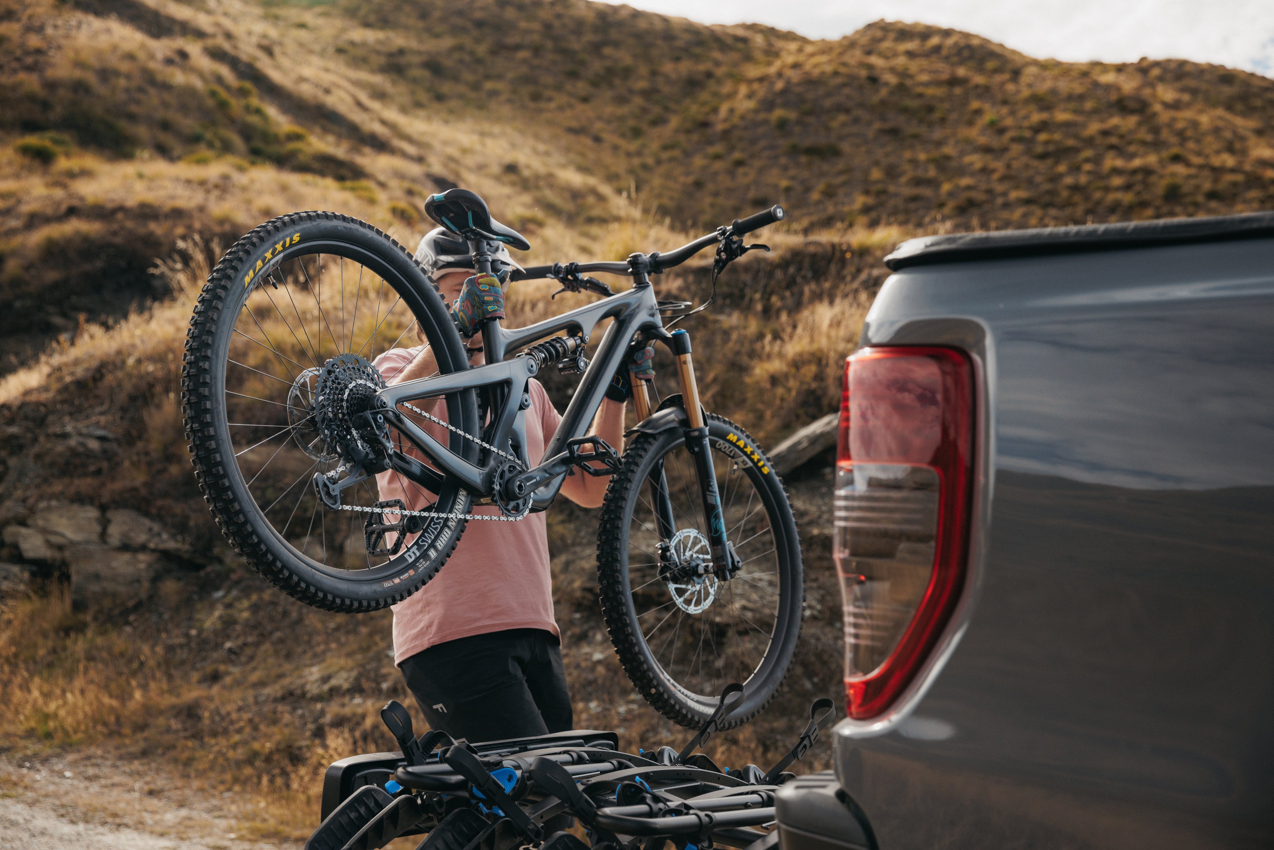 A man is lifting a bike onto a bike rack