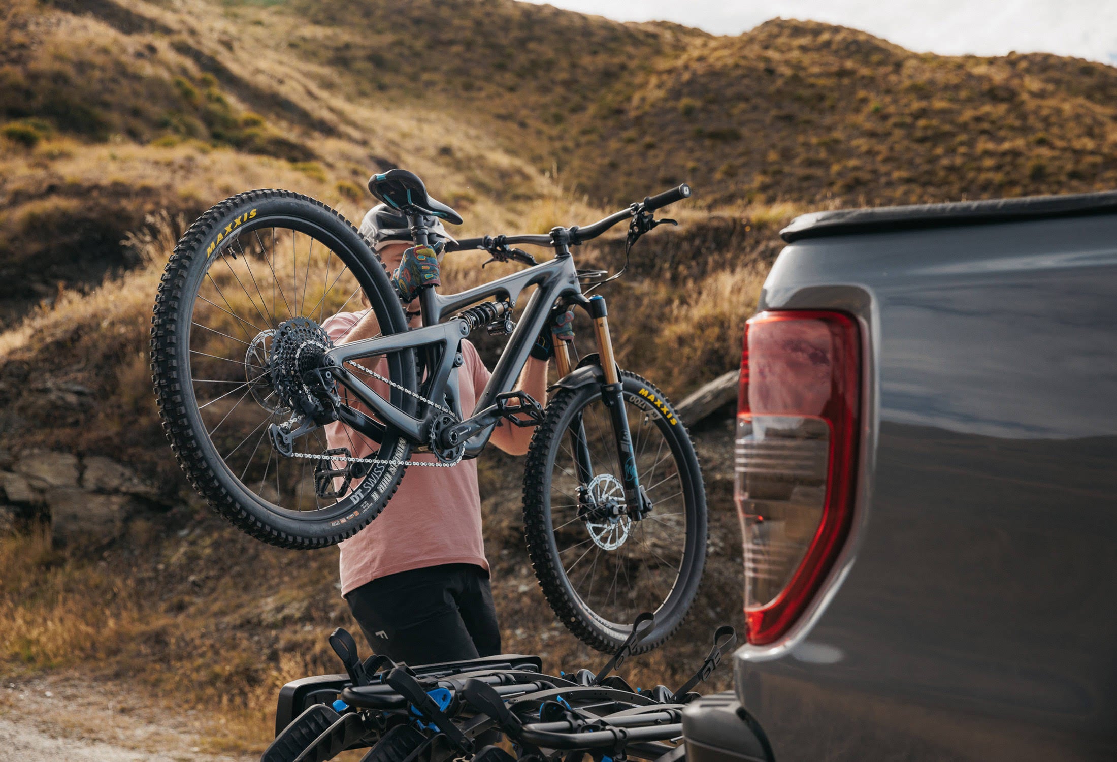 A man loads a mtb onto an Ezigrip Enduro 4 bike rack. The bike rack is empty and all uprights are folded down.